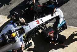 The Lewis Hamilton, Mercedes AMG F1 W08, is attended to by mechanics in the pit lane