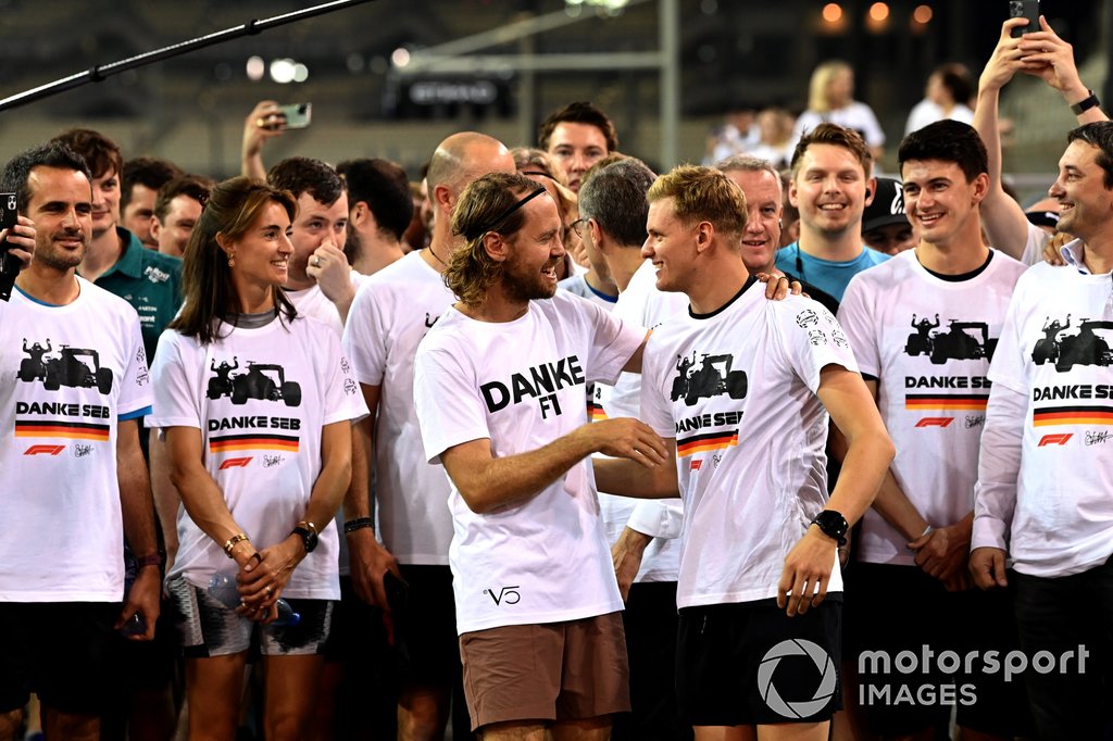 Sebastian Vettel, Aston Martin, es acompañado en una carrera alrededor del circuito por Mick Schumacher, Haas F1 Team, los miembros del equipo y los buenos deseos como parte de su despedida en su último Gran Premio