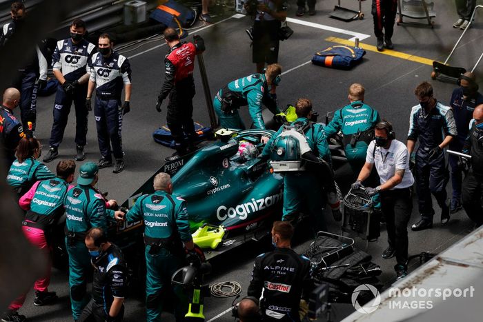 Mecánicos empujan el coche de Sebastian Vettel, Aston Martin AMR21