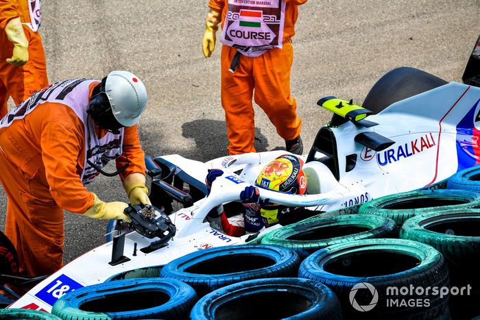 Los oficiales de pista asisten a Mick Schumacher, Haas VF-21, tras su accidente en la FP3