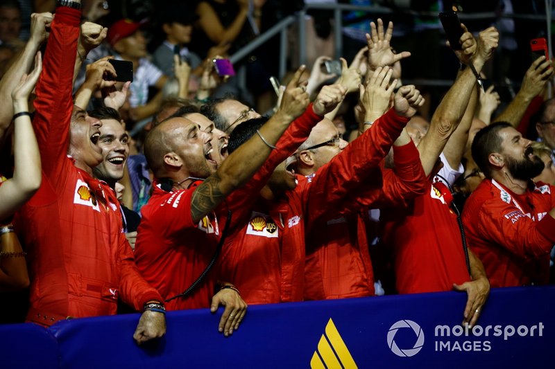 The Ferrari team cheer for their drivers on the podium