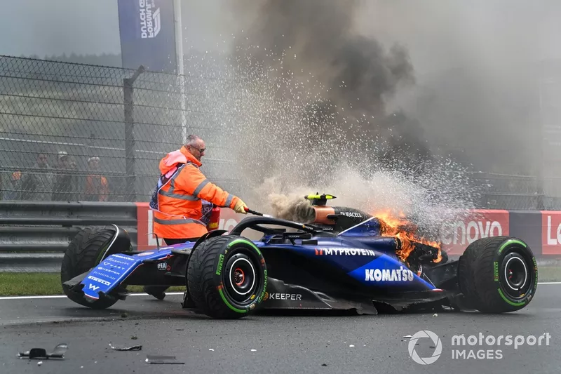 Un commissaire utilise un extincteur sur la voiture de Logan Sargeant, Williams FW46, après un accident en FP3.
