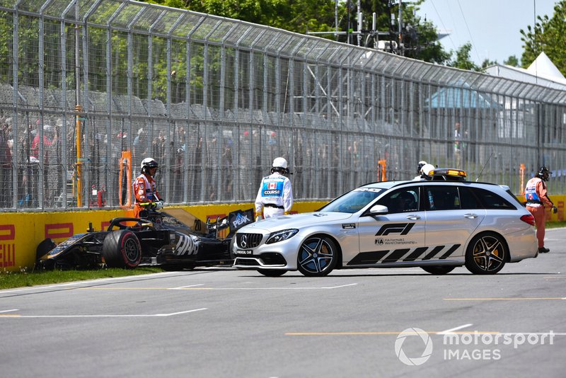 El coche médico y los oficiales atienden al coche dañado de Kevin Magnussen, Haas F1 Team VF-19