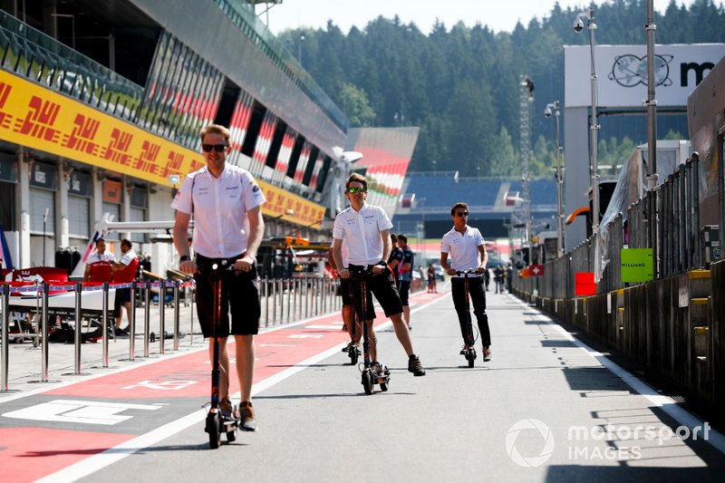 Lando Norris, McLaren y miembros de McLaren en patinetes