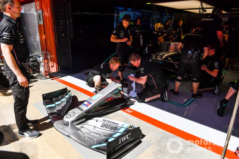 mechanics work on the car of Lewis Hamilton, Mercedes AMG F1 W10, in the garage