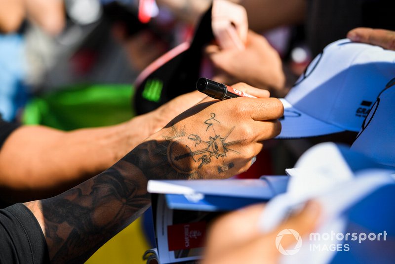 Hands of Lewis Hamilton, Mercedes AMG F1 signing an autograph for a fan
