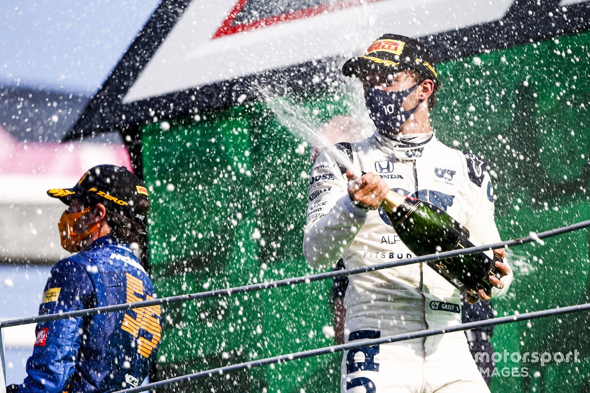 Carlos Sainz Jr., McLaren, 2nd position, and Pierre Gasly, AlphaTauri, 1st position, spray Champagne on the podium