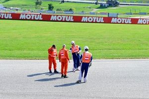Los comisarios comprueban la pista tras una bandera roja.