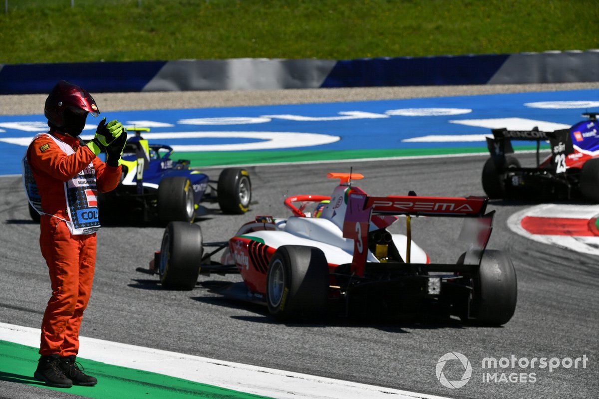 Un oficial de pista aplaude a Alexander Smolvar, ART Grand Prix Enaam Ahmed, Carlin, y a Logan Sargeant, Prema Racing, que pasan por aquí.