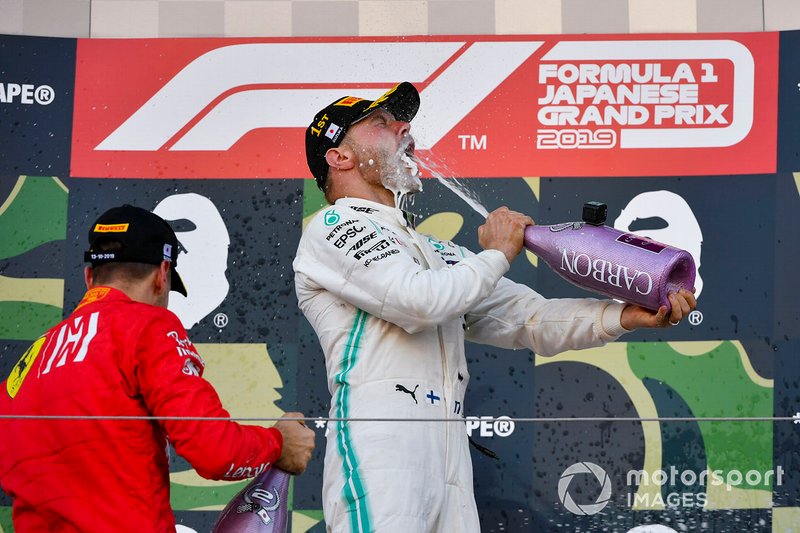 Sebastian Vettel, Ferrari, 2nd position, and Valtteri Bottas, Mercedes AMG F1, 1st position, celebrate on the podium with Champagne