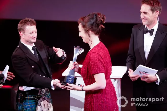 Allan McNish en el escenario para entregar el Premio Pionero y de Innovación a Catherine Bond Muir de la W Series