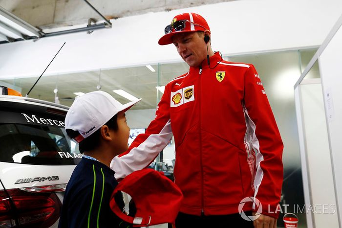 Kimi Raikkonen, Ferrari, meets a Chinese child