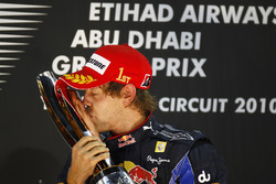 Le Champion du monde Sebastian Vettel, Red Bull Racing RB6 Renault embrasse son trophée sur le podium