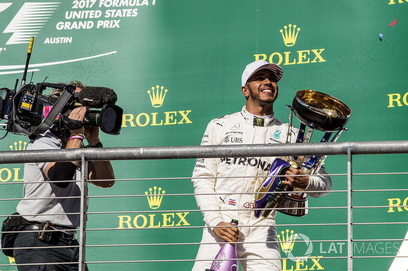 El ganador de la carrera Lewis Hamilton, Mercedes AMG F1 celebra en el podio con el trofeo, champagne y las zapatillas de Usain Bolt