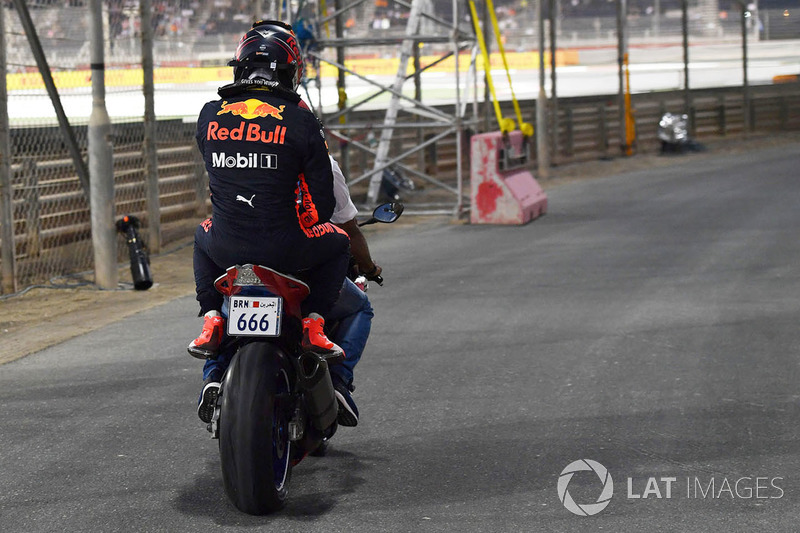 Max Verstappen, Red Bull Racing crashed in Q1 and is given a lift on a motorbike