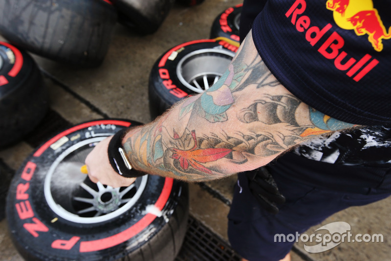 A Red Bull Racing mechanic washes some Super Soft tyres and rims