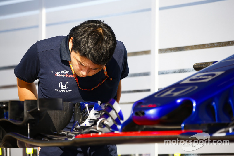 Un membro del team Toro Rosso Honda ispeziona un'ala anteriore