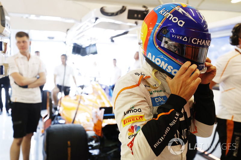 Fernando Alonso, McLaren, puts on his helmet in the garage