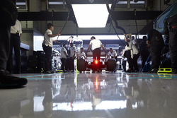 Engineers return a Mercedes AMG F1 W09 to their garage