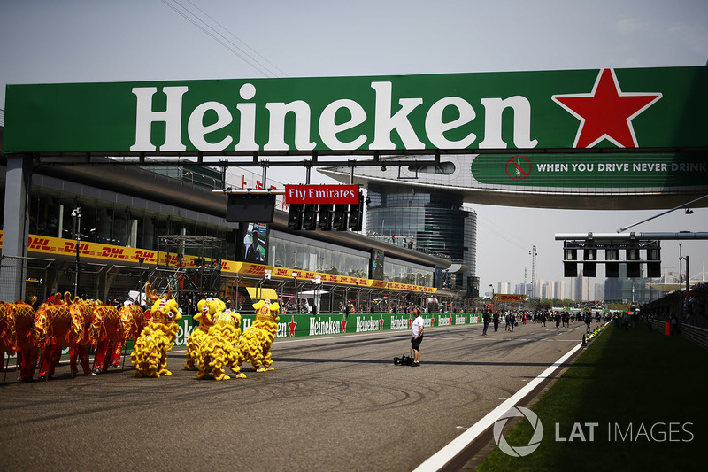 Performers in Chinese dragon costumes on the grid beneath a Heineken bridge and start light gantry