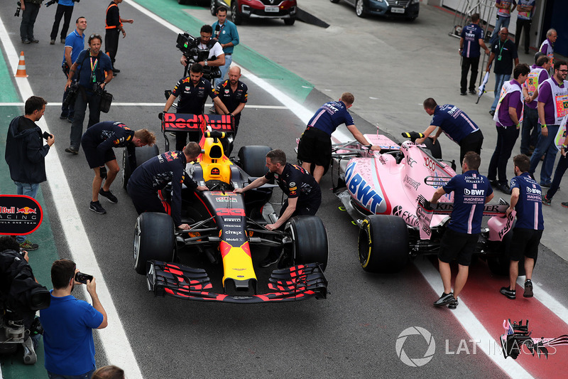 El coche de Max Verstappen, Red Bull Racing RB13 y Esteban Ocon, Sahara Force India VJM10 son empujados por la mecánica