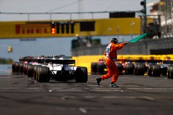 The lights come on and a marshal gives the green flag for the start