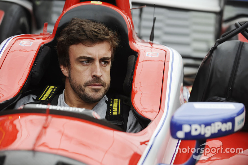 Fernando Alonso sits in the car of Marco Andretti