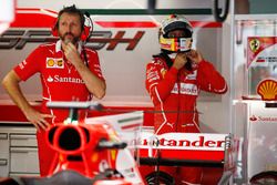 A Ferrari team member stands in front of Sebastian Vettel, Ferrari