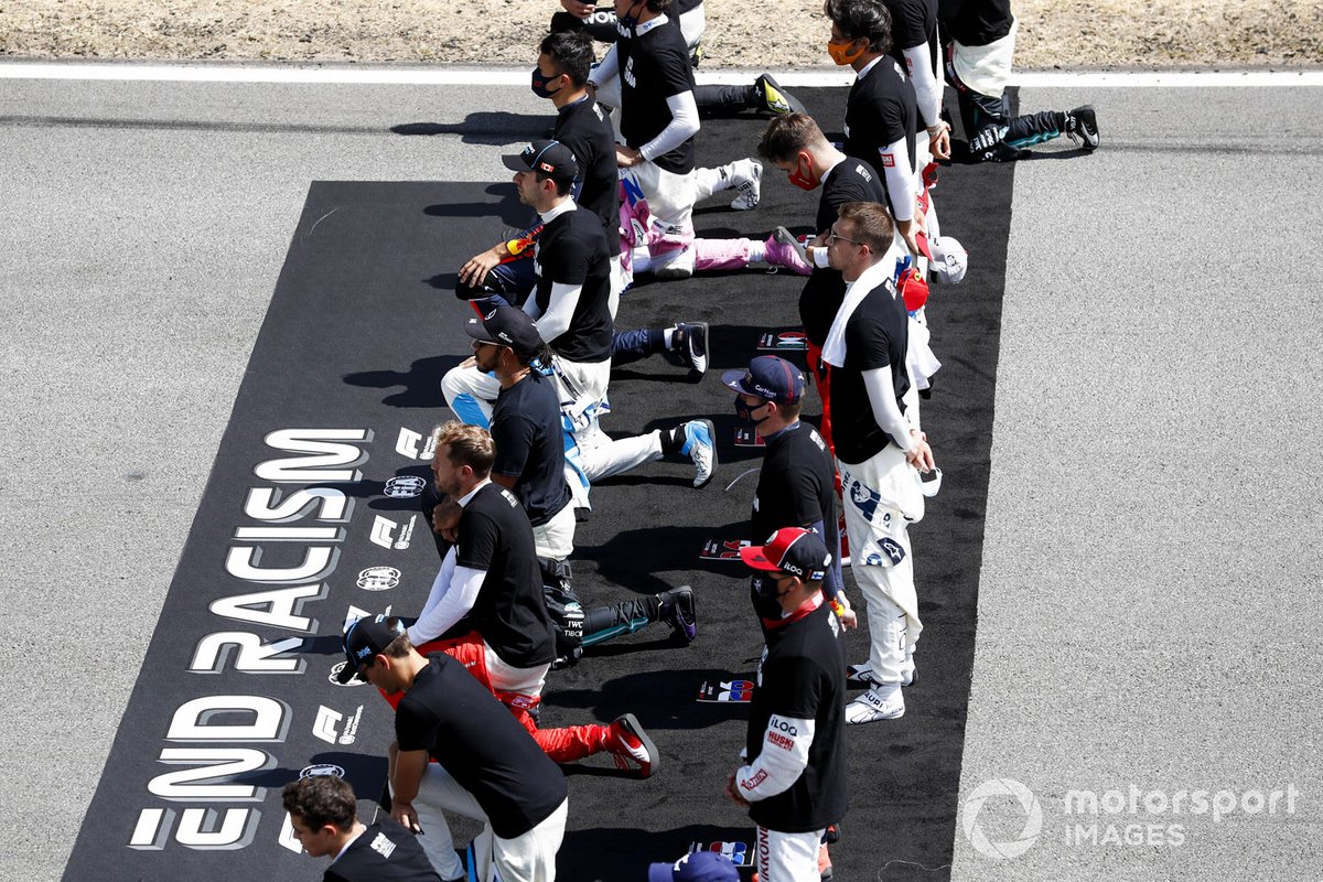 The drivers stand kneel in support of the End Racism campaign prior to the start