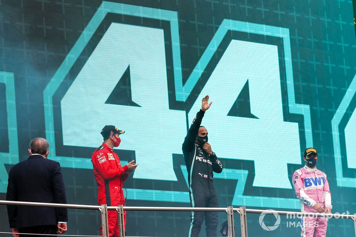 Lewis Hamilton, Mercedes-AMG F1, on the podium after winning the race, to take his 7th World Championship title, with Sergio Perez, Racing Point, 2nd position, and Sebastian Vettel, Ferrari, 3rd position 