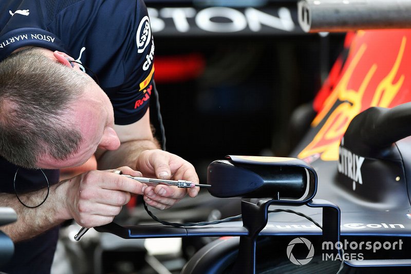 An engineer adjusts a wing mirror on the Red Bull Racing RB15