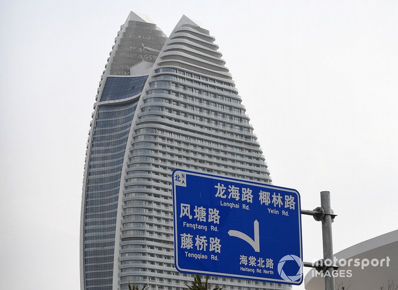 A road sign, a skyscraper in the background