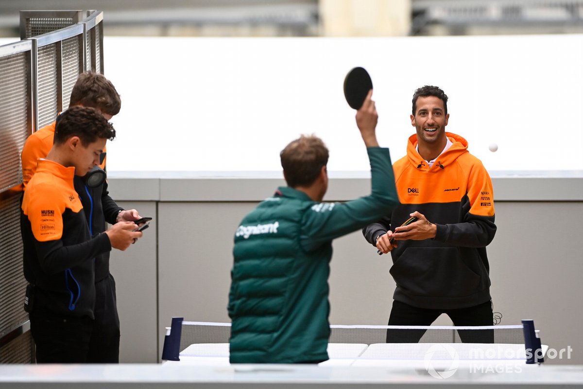 Daniel Ricciardo, McLaren, y Sebastian Vettel, Aston Martin, jugando al ping-pong con Lando Norris, McLaren