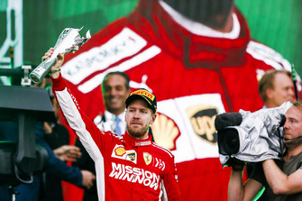 Sebastian Vettel, Ferrari, 2nd position, lifts his trophy on the podium