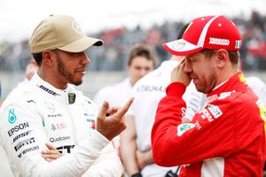 Lewis Hamilton, Mercedes AMG F1, talks with Sebastian Vettel, Ferrari, after taking Pole Position