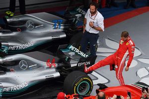 Sebastian Vettel, Ferrari regarde le pneu arrière de la voiture de Lewis Hamilton, Mercedes-AMG F1 W09 dans le Parc Fermé