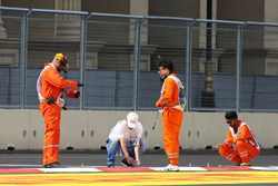 Marshals work on the kerbs after GP2 qualifying is postponed