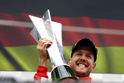 Sebastian Vettel, Ferrari, 1st position, celebrates on the podium with his trophy