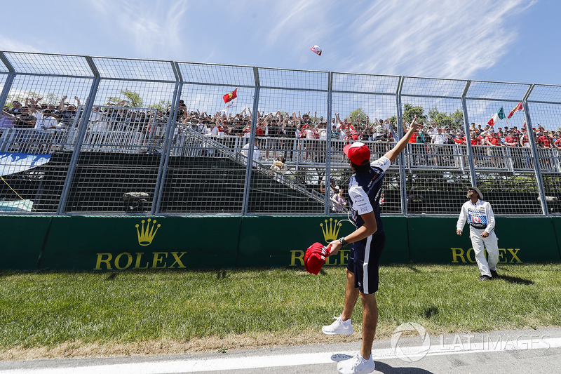 Lance Stroll, Williams Racing, throws hats into a crowd of fans