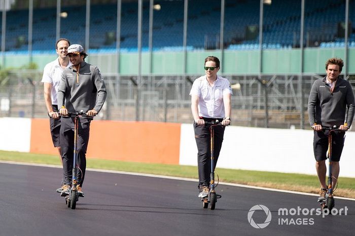 Carlos Sainz Jr., McLaren camina por la pista en un scooter