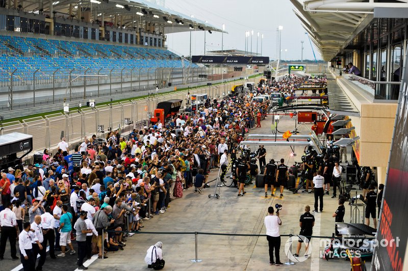 Los fanáticos en el pit lane observan al equipo Mercedes AMG F1 hacer una práctica de parada en boxes