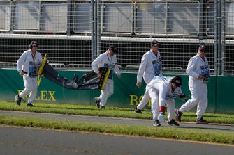 Marshals remove the front wing and debris belonging to the car of Daniel Ricciardo, Renault, from the circuit