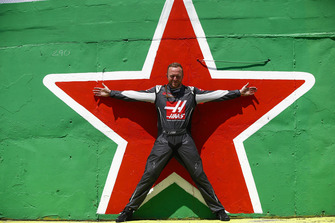 A Haas team member stands in front of a Heineken star.