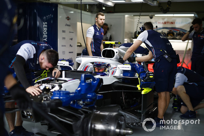 Les mécaniciens sur la voiture de Sergey Sirotkin Williams FW41 dans le garage