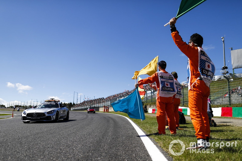 Marshals wave flags as the Safety Car passes ahead of the drivers parade