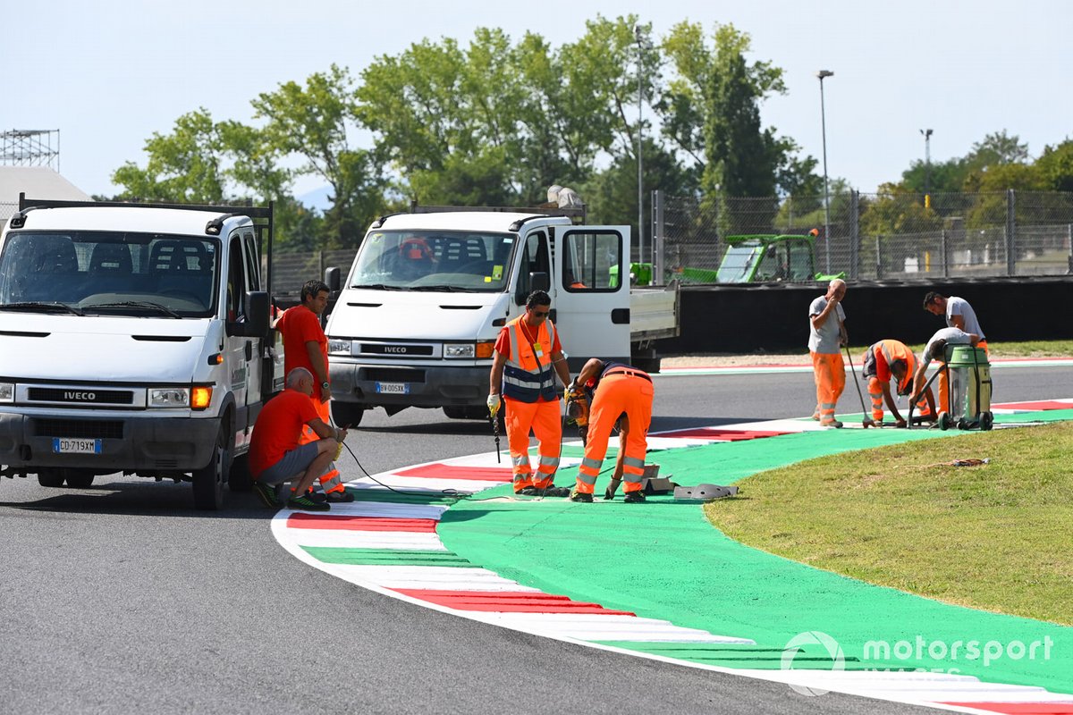 Operai riparano la pista e il cordolo
