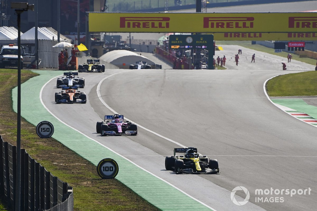 Daniel Ricciardo, Renault F1 Team R.S.20, Lance Stroll, Racing Point RP20, Carlos Sainz Jr., McLaren MCL35, and the rest of the field out of the pits for the restart