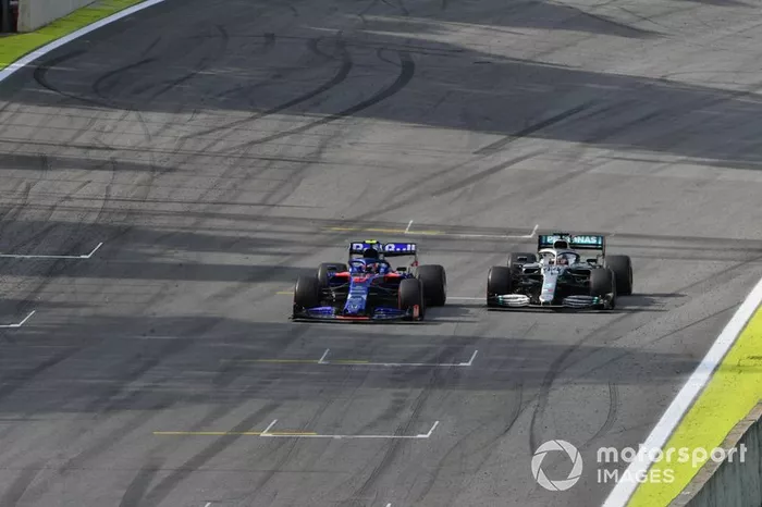 Pierre Gasly, Toro Rosso STR14, and Lewis Hamilton, Mercedes AMG F1 W10, race towards the chequered flag