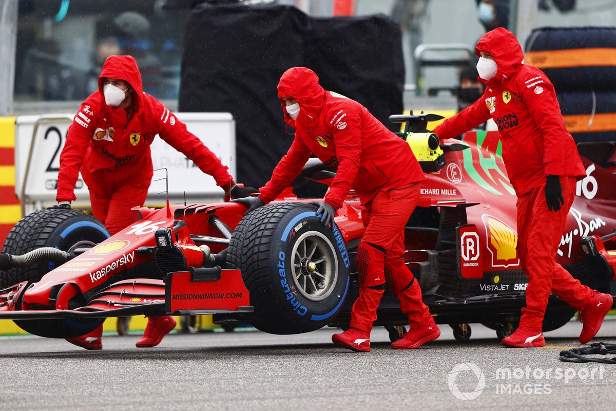 Los mecánicos empujan el coche de Charles Leclerc, Ferrari SF21, en la parrilla de salida