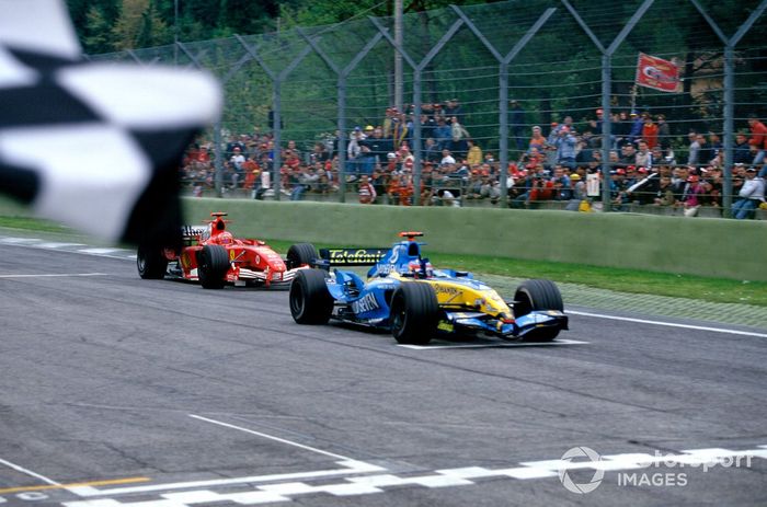 El ganador de la carrera, Fernando Alonso (Renault R25), toma la bandera a cuadros, seguido de cerca por Michael Schumacher (Ferrari F2005).